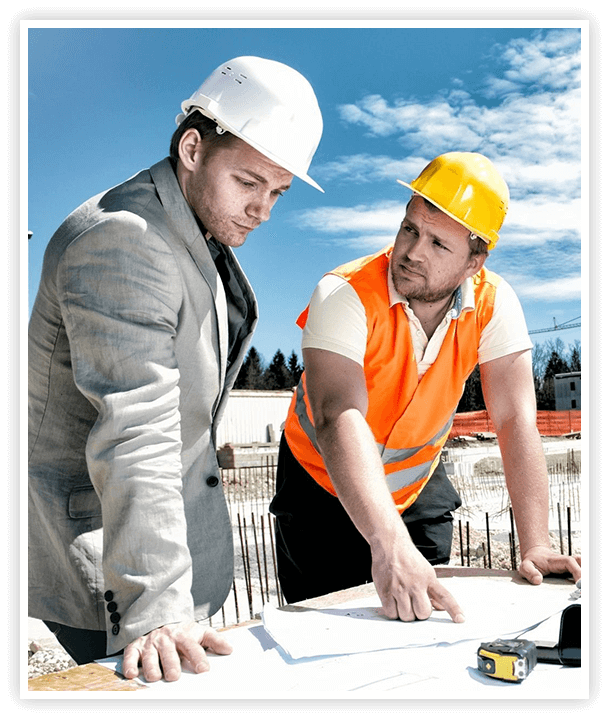 Two workers reviewing blueprints for construction at construction site.